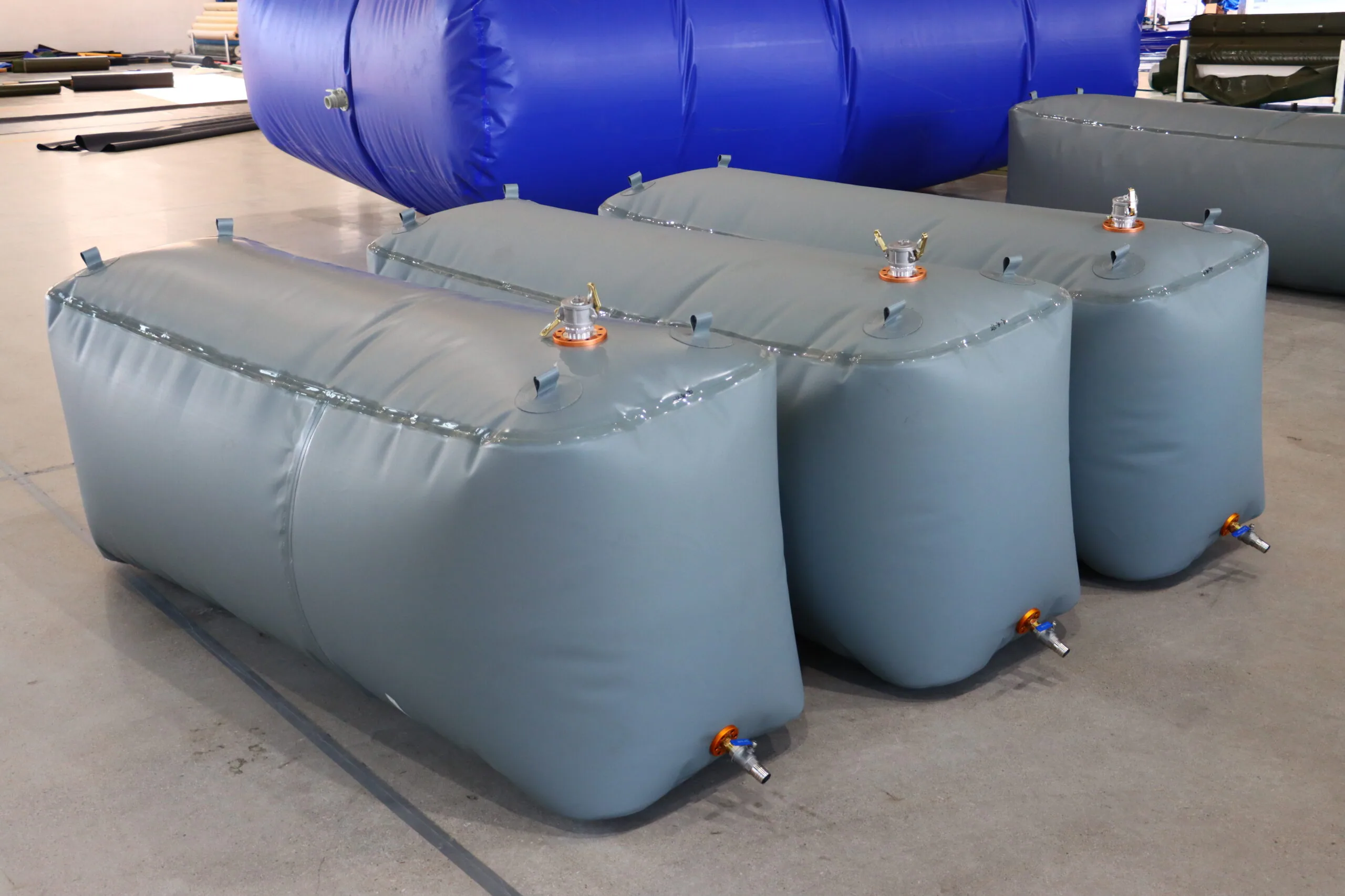 Grey flexible fuel bladder tanks arranged inside the factory