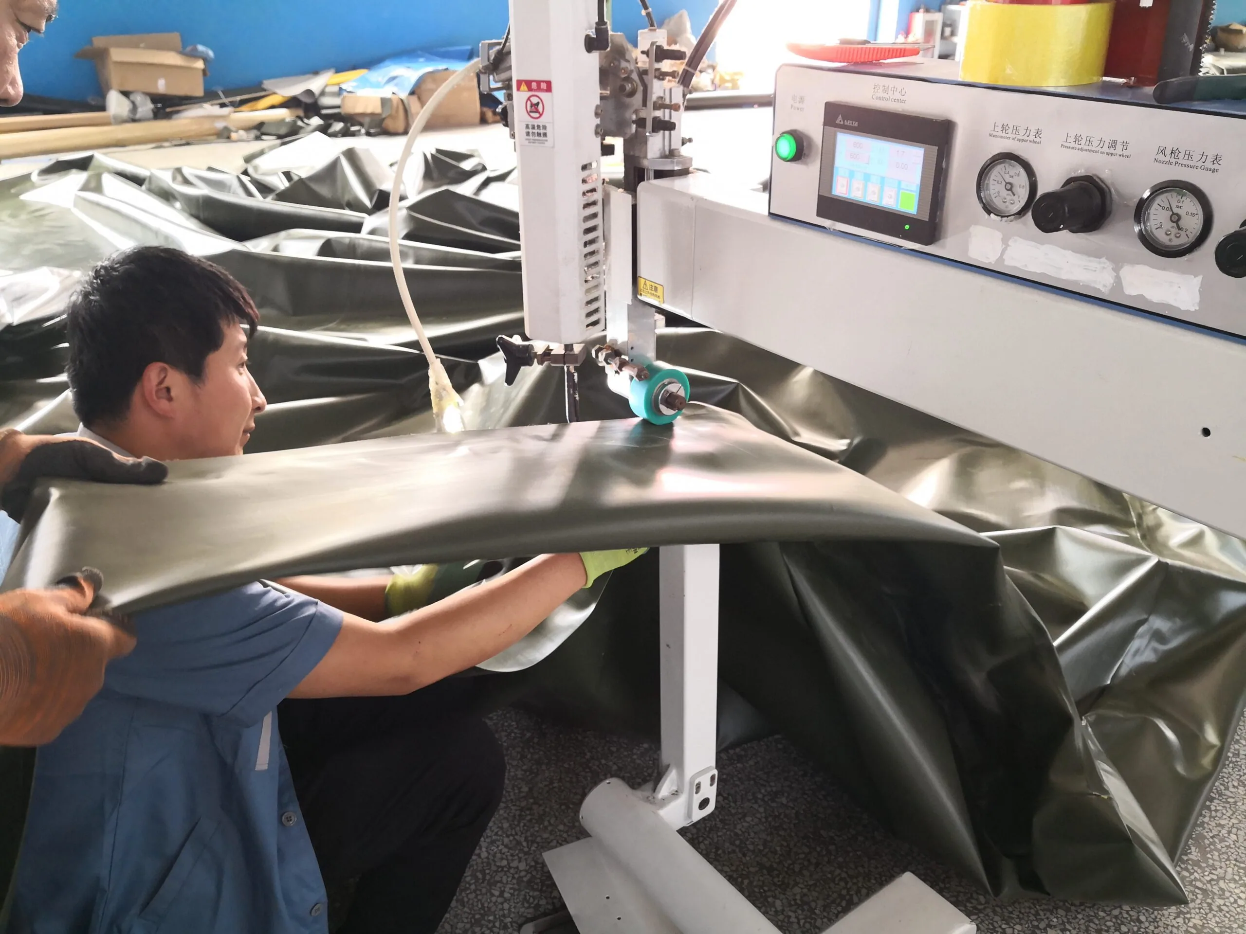 FUUSHAN workers heat-sealing flexible tank material in the manufacturing workshop