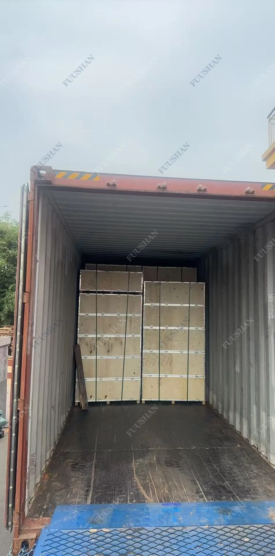 Vista desde la puerta abierta del contenedor hacia las cajas de madera