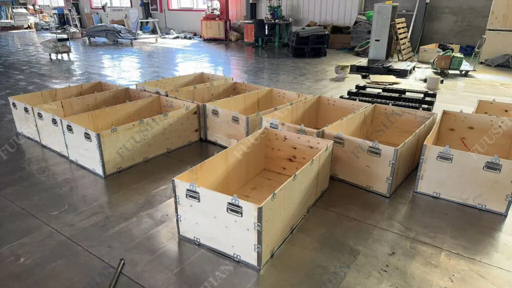 Open wooden export crates in the FUUSHAN workshop prepared for flexible water bladder shipment