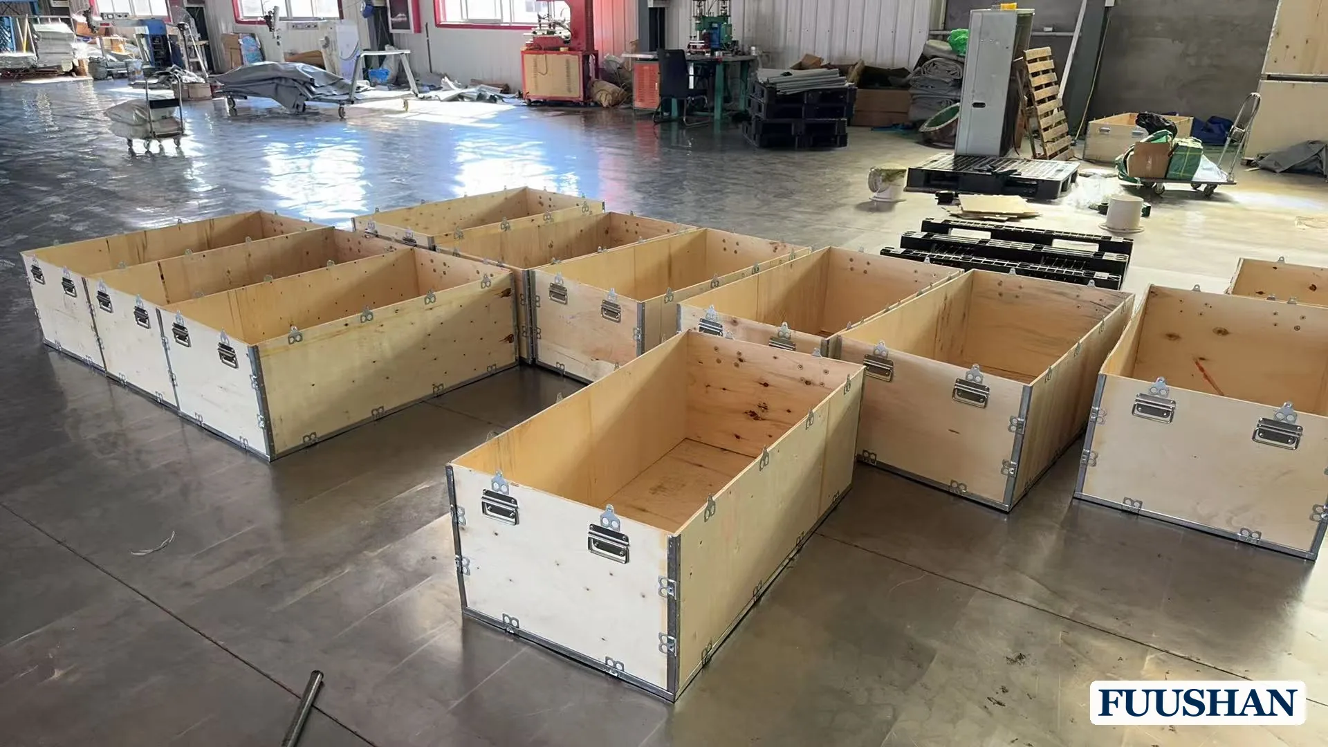 Open wooden export crates in the FUUSHAN workshop prepared for flexible water bladder shipment