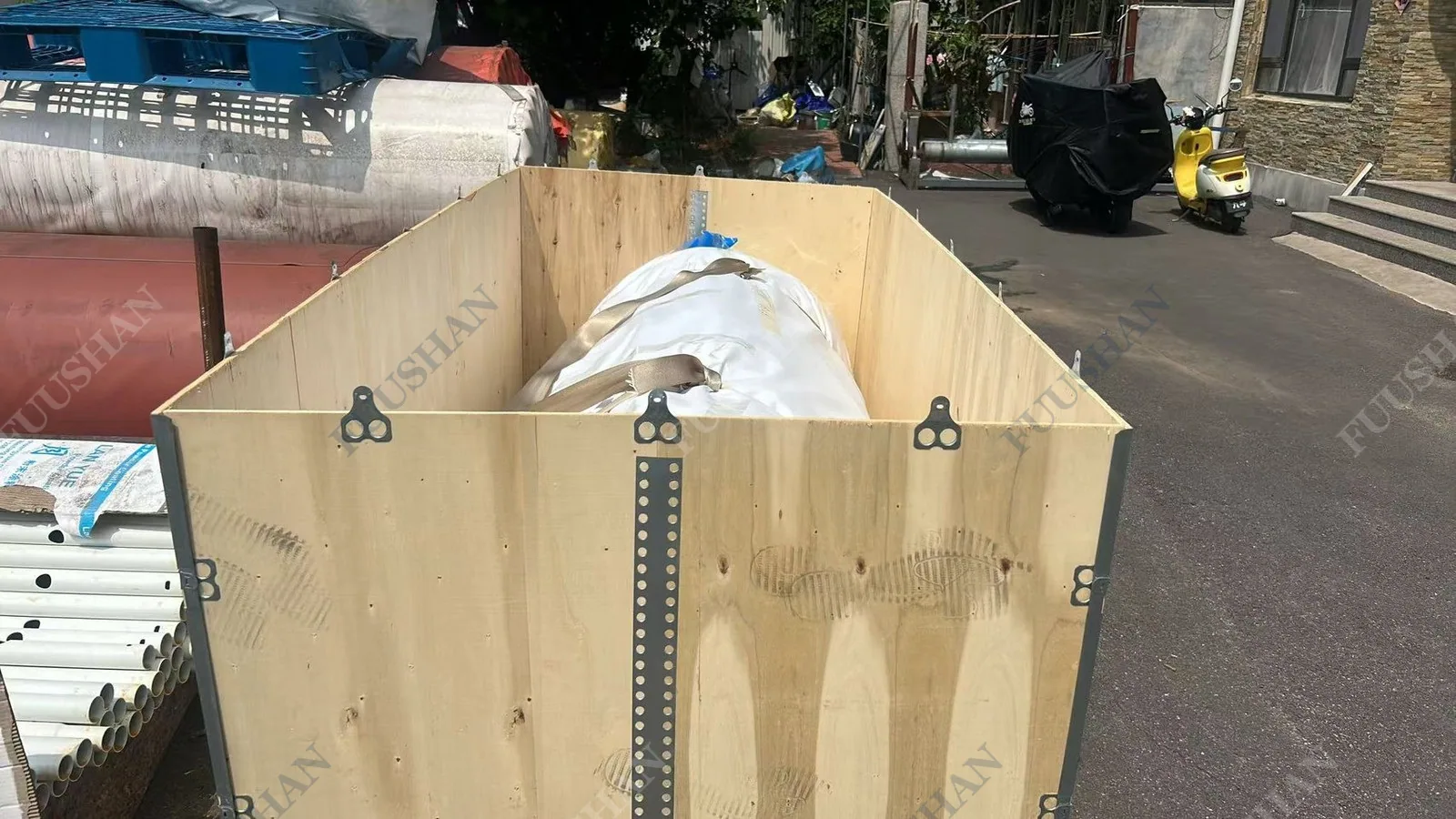 Wrapped tank unit strapped inside an open wooden crate